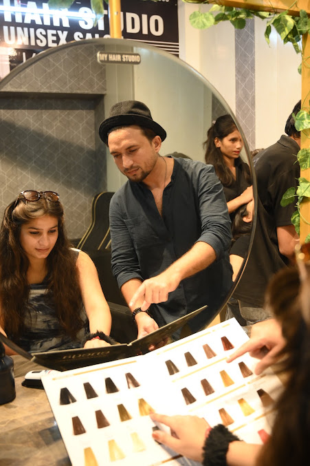 Stylist consulting a client with a hair-colour swatch book at My Hair Studio